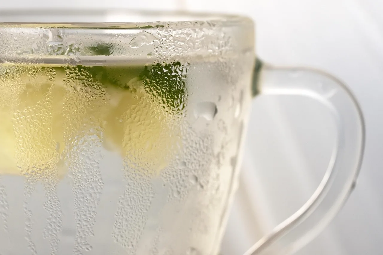 Bicchiere d'acqua tiepida su un tavolo, simbolo di detox per il fegato durante la notte.